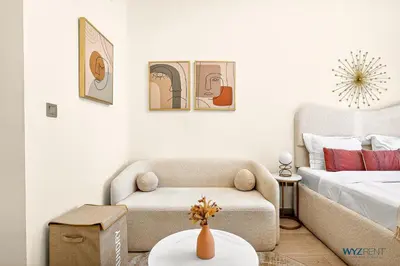 a living room with a chair and a bed at Winter Wonderland Studio Azizi Riviera 9 Pool View in Dubai