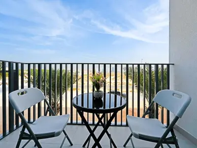 a balcony with a table and two chairs on a balcony at Elegant Modern Studio- Peaceful Studio City in Dubai