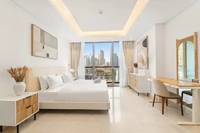 a white bedroom with a bed and a desk at FIRST CLASS 1BR Burj Views , Prime Location in Dubai