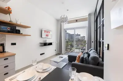a living room with a couch and a table at StayShort - Modern Dubai Hills Apartment Great Pool Sleeps 4 in Dubai