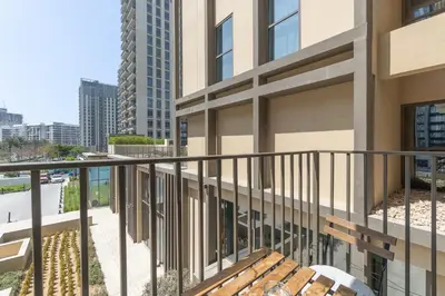 a balcony of a building with a wooden bench at StayShort - Modern Dubai Hills Apartment Great Pool Sleeps 4 in Dubai