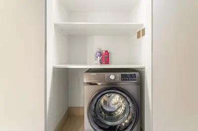 a washer and dryer in a white laundry room at FIRST CLASS 2BR Burj View , Walk to Dubai Mall in Dubai