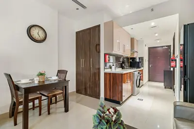 a kitchen with a table and a clock on the wall at FIRST CLASS Studio Iconic Burj Khalifa View in Dubai