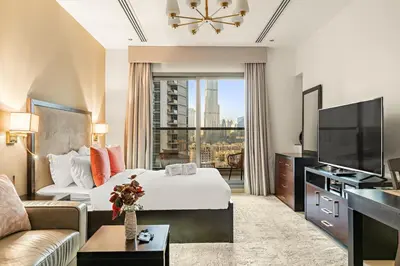 a hotel room with a bed and a television at FIRST CLASS Studio Iconic Burj Khalifa View in Dubai