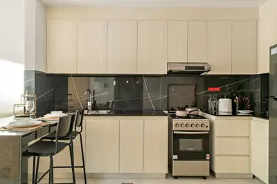 a kitchen with white cabinets and a stove at FIRST CLASS 1BR Tranquil Pool View Retreat in Dubai