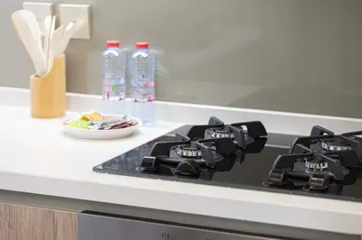a stove top in a kitchen with bottles of water at Lux 1BR with Stunning Canal Views in Dubai