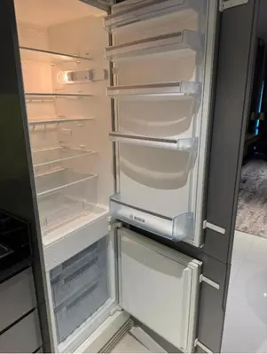 an empty refrigerator with its door open in a kitchen at Exquisite Studio - Damac Prive with balcony & canal view in Dubai