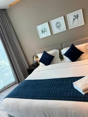 a bedroom with a large bed with blue and white pillows at Exquisite Studio - Damac Prive with balcony & canal view in Dubai