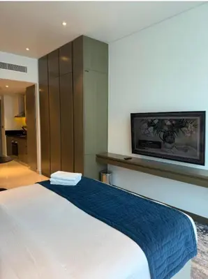 a bedroom with a bed with a tv on the wall at Exquisite Studio - Damac Prive with balcony & canal view in Dubai