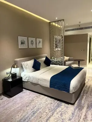 a bedroom with a large bed with a blue blanket at Exquisite Studio - Damac Prive with balcony & canal view in Dubai