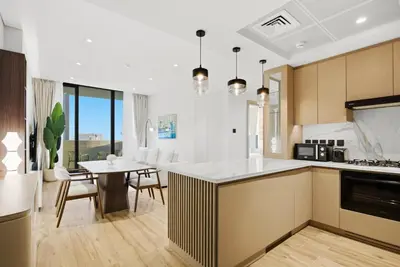 a kitchen with a table and a dining room at Chic 2Bedroom with Exceptional Facilities in JVC in Dubai