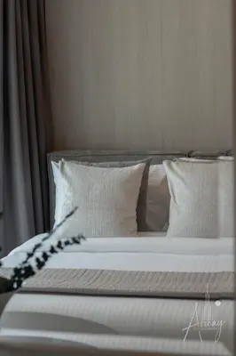 a bed with white sheets and pillows at Sunlit Luxe Studio Serene Skies Infinity Pool in Dubai