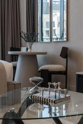 a living room with a glass table and chairs at Sunlit Luxe Studio Serene Skies Infinity Pool in Dubai