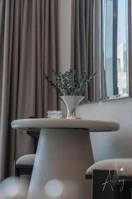 a table with a vase on top of it at Sunlit Luxe Studio Serene Skies Infinity Pool in Dubai