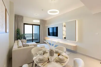 a living room with a couch and a table and chairs at Luxury 1 Bedroom Sway Residences Dubai Hills in Dubai