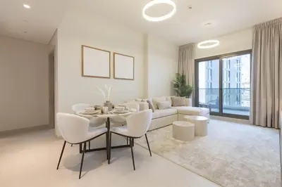 a white living room with a table and a couch at Luxury 1 Bedroom Sway Residences Dubai Hills in Dubai