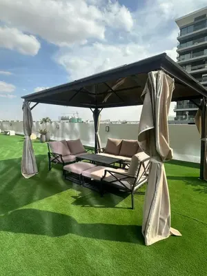 a group of chairs under a canopy on a lawn at Luxury 1 Bedroom Sway Residences Dubai Hills in Dubai