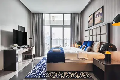 a bedroom with a bed and a desk and a television at Luxury Studio Cozy & comfy 12 Min Walk-Dubai Mall in Dubai