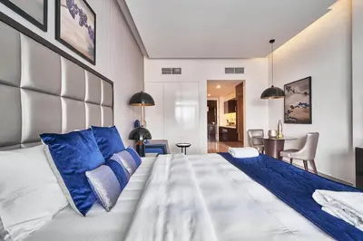 a bedroom with a large bed with blue pillows at Luxury Studio Cozy & comfy 12 Min Walk-Dubai Mall in Dubai