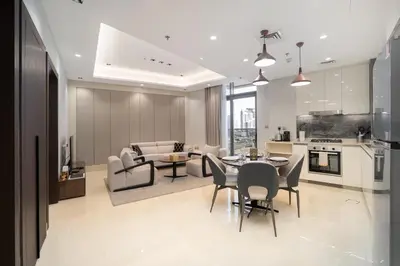 a kitchen and living room with a table and chairs at Luxury 1BR in Nobles Tower - Business Bay Skyline in Dubai