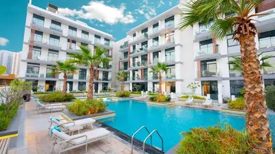 an apartment building with a swimming pool and palm trees at Luxurious Cozy Studio with Balcony Pool & Gym in Dubai