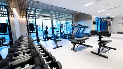 a gym with rows of treadmills and machines at Luxurious Cozy Studio with Balcony Pool & Gym in Dubai