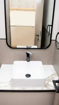 a white sink in front of a mirror at Luxurious Cozy Studio with Balcony Pool & Gym in Dubai