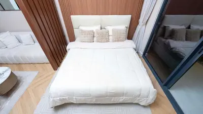 a large white bed in a small room at Luxurious Cozy Studio with Balcony Pool & Gym in Dubai