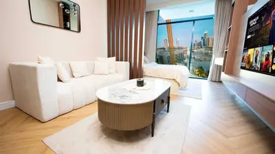a living room with a white couch and a table at Luxurious Cozy Studio with Balcony Pool & Gym in Dubai