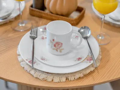 a table with a plate with a cup and a spoon at Luxury 2BHK with view of Burj Khalifa & Fountain in Dubai