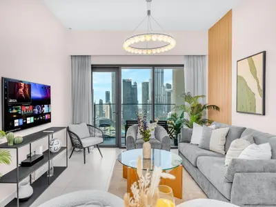 a living room with a couch and a tv at Luxury 2BHK with view of Burj Khalifa & Fountain in Dubai