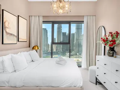 a bedroom with a white bed and a large window at Luxury 2BHK with view of Burj Khalifa & Fountain in Dubai