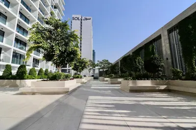 an empty sidewalk in front of a building at Rentico l Luxury 1BR with Burj Khalifa & Canal View in Dubai
