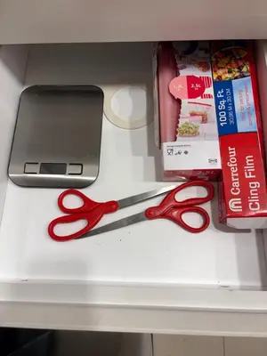 a pair of red scissors sitting on a shelf at Prime Pool Location Spacious Family Villa in Dubai