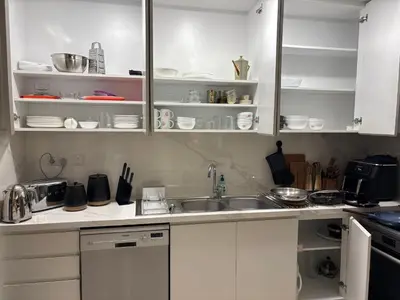 a kitchen with white cabinets and a sink at Prime Pool Location Spacious Family Villa in Dubai