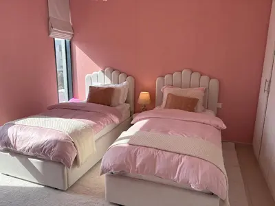 two beds in a bedroom with pink walls at Prime Pool Location Spacious Family Villa in Dubai
