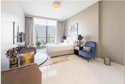 a hotel room with a bed and a table and chairs at Serene Golf Course Studio in Artesia Damac Hills in Dubai Marina