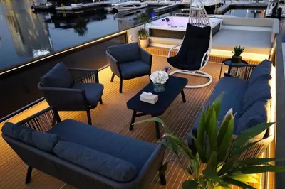a balcony with chairs and couches on a boat at Luxury Yacht in Dubai Marina - Private Charter in Dubai