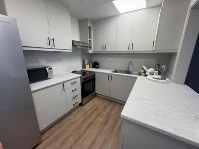 a kitchen with white cabinets and a counter top at Two bedroom Apartment in JBR Marina - 2 min walk to JBR beach in Dubai