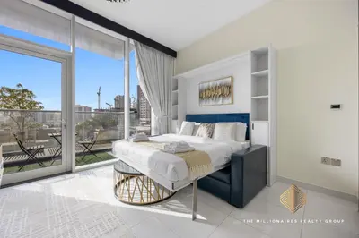 a bedroom with a bed and a large window at Elegant Studio with Resort Amenities at Miraclez in Dubai