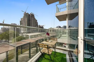 a balcony with a table and chairs on a building at Elegant Studio with Resort Amenities at Miraclez in Dubai