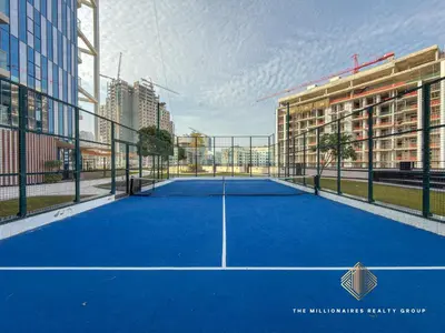 a tennis court in the middle of a city at Elegant Studio with Resort Amenities at Miraclez in Dubai