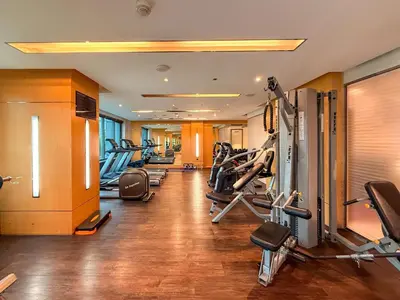 a gym with a row of treadmills and machines at Elegant 1BR near downtown w Gym Tennis Basketball Courts in Dubai