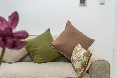a couch with pillows and a purple flower on it at Elegant 1BR near downtown w Gym Tennis Basketball Courts in Dubai