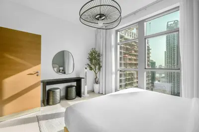 a white bedroom with a large window and a bed at Perfect Getaway in Downtown l Near Dubai Mall in Dubai