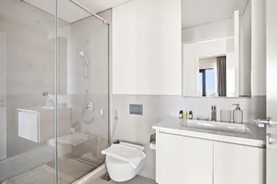 a bathroom with a shower and a toilet and a sink at Silkhaus Stylish 1BDR with Pool & Balcony Dubai Creek Harbour in Dubai
