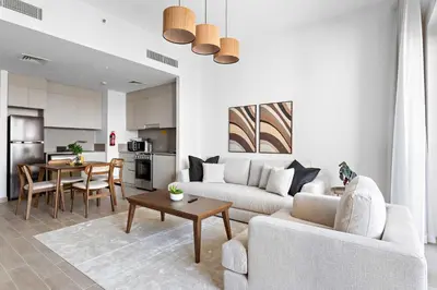 a living room with a couch and a table at Silkhaus Stylish 1BDR with Pool & Balcony Dubai Creek Harbour in Dubai