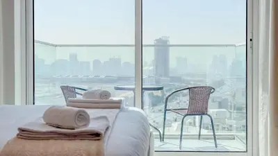 a bedroom with a bed and a view of a city at TRPS - Skyz by Danube, Arjan - Close to Miracle Garden, Furnished, Brand New in Dubai