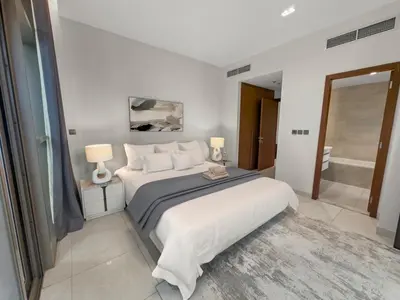 a white bedroom with a large bed and a bathroom at Stylish Deluxe Two Bedrooms In Dubai Marina in Dubai