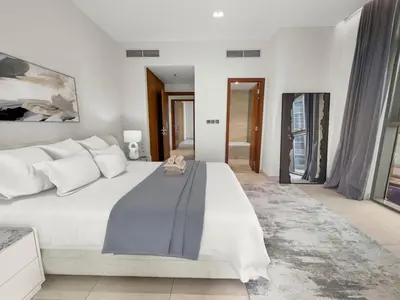 a white bedroom with a large white bed with white pillows at Stylish Deluxe Two Bedrooms In Dubai Marina in Dubai